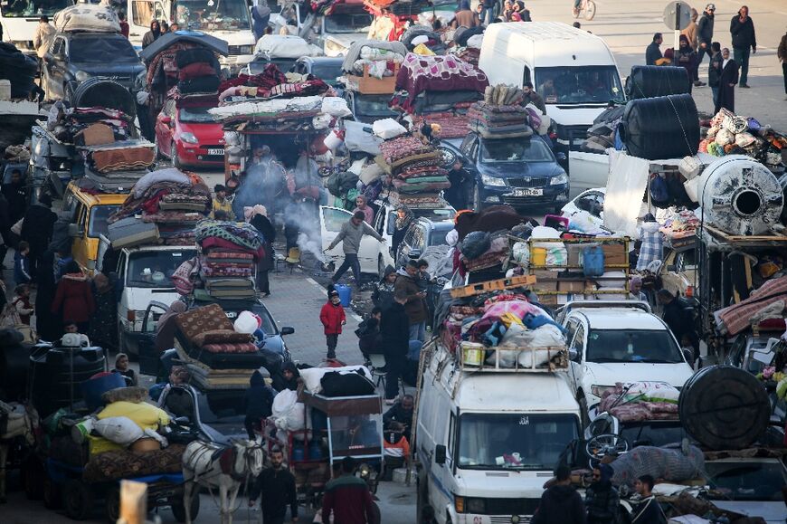 Displaced Palestinians hoping to return to northern Gaza wait along Salah al-Din road near the blocked Netzarim corridor, after a last-minute dispute halted their return during a truce between Israel and Hamas