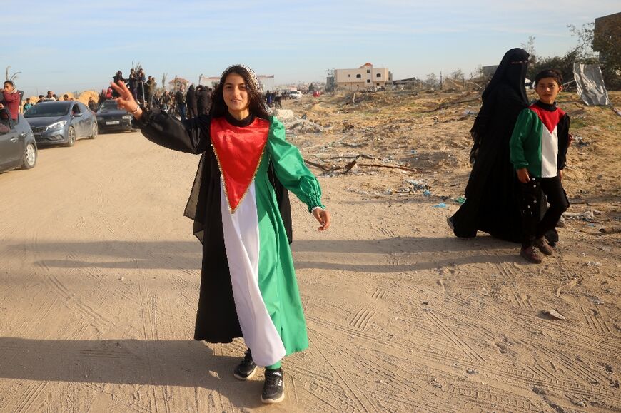 A young woman wears a dress in the colours of the Palestinian flag, celebrating the ceasefire