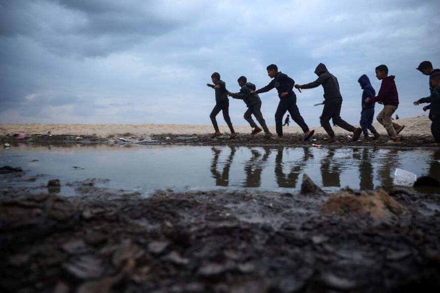 Displaced Palestinian children play near tents along a beach in Deir el-Balah on the fourth day of a ceasefire deal in the war between Israel and Hamas 