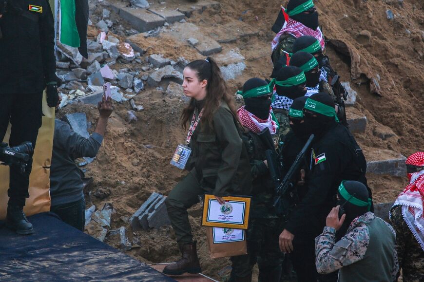 Hamas militants escort hostage Agam Berger onto a makeshift stage before her release in Jabalia