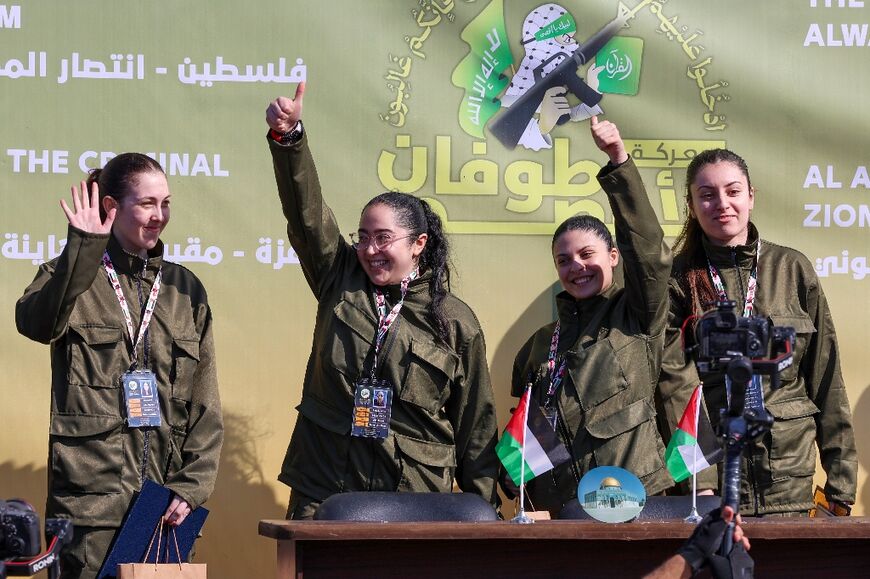 Four Israeli hostages, (L-R) Naama Levy, Liri Albag, Daniella Gilboa and Karina Ariev, wave on a stage in Gaza before Hamas fighters hand them over to the Red Cross -- an Israeli medical officer called it a deceiving 'show'