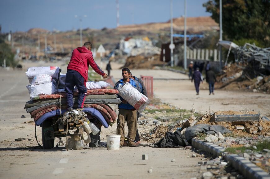 Displaced people load a cart with their belongings near a roadblock in Nuseirat, central Gaza, while waiting to return to the northern part of the Palestinian territory -- a last-minute dispute delayed such returns 