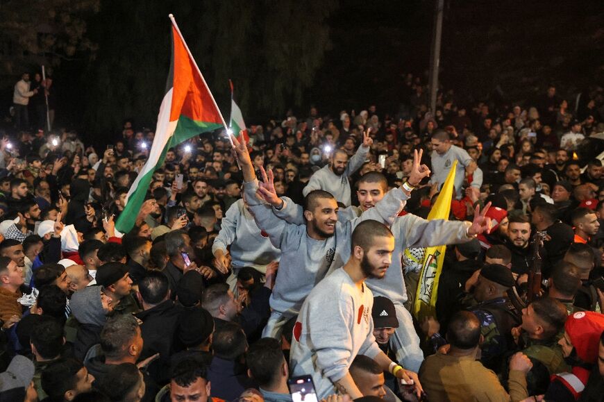 A crowd welcomes Palestinians formerly jailed by Israel as they arrive in a Red Cross convoy to Ramallah in the occupied West Bank