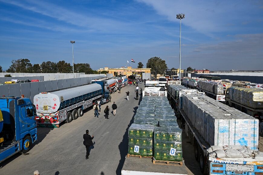 Trucks loaded with aid wait to cross into Gaza from the Egyptian side of the Rafah border crossing on the first day of the ceasefire between Israel and Hamas