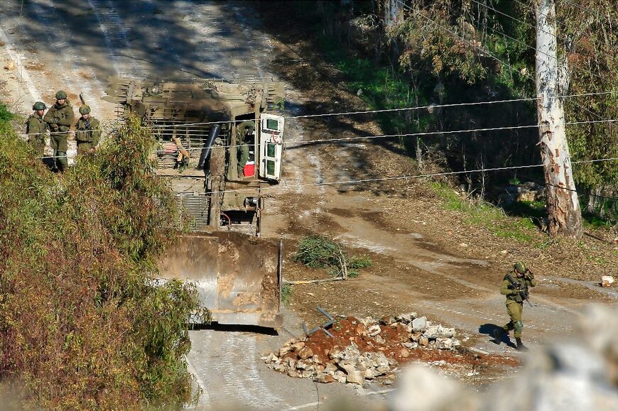 Israeli army troops with a bulldozer at a makeshift barricade near the southern Lebanese village of Houla, a day ahead of a deadline for Israeli withdrawal from southern Lebanon under a ceasefire with Hezbollah