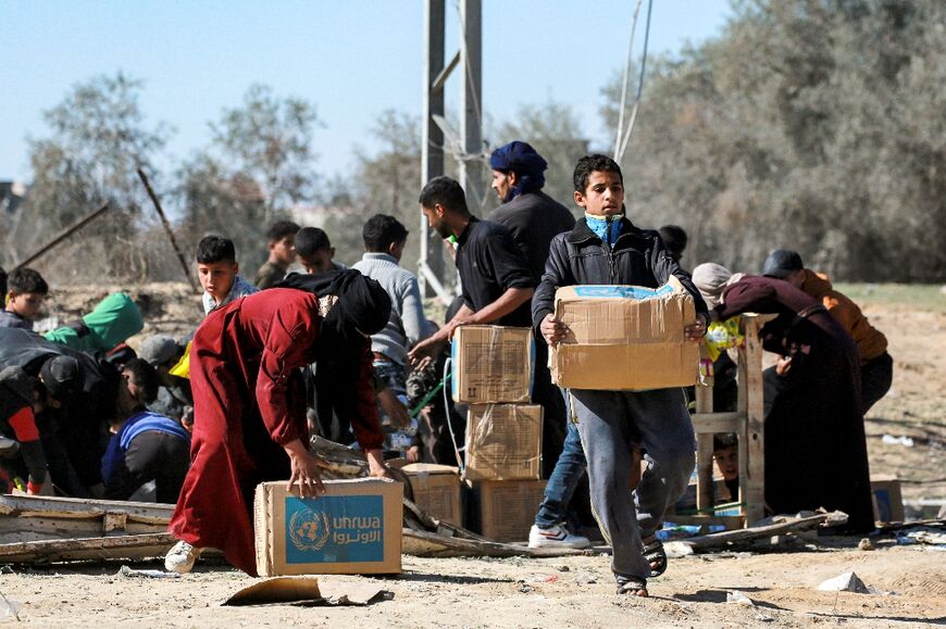 A boy in Al-Shoka receives an aid package provided by UNRWA.