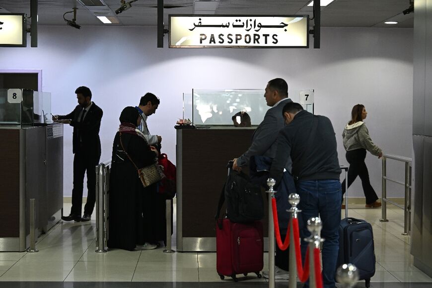 Passengers queue for passport checks before boarding their flight at Damascus airport on Tuesday