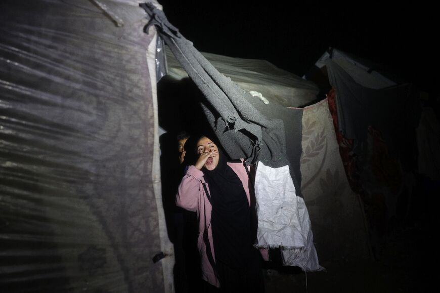 A Palestinian girl cheers at a camp for people displaced by conflict in Deir el-Balah