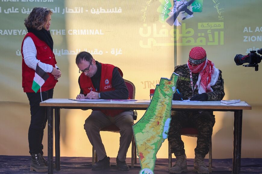 A Red Cross member signs documents before Hamas militants release Israeli hostage Agam Berger in Jabalia