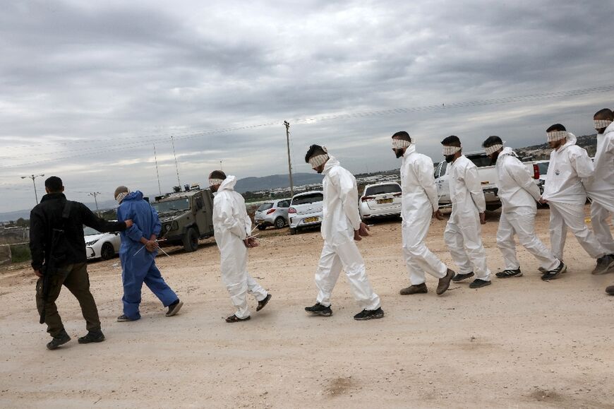 An Israeli soldier supervises the transfer of Palestinian men arrested during a military raid on Jenin