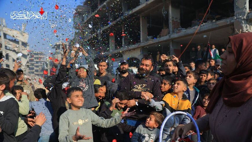 This handout image released by the Hamas Media Office shows Palestinians celebrating during the handover of an Israeli hostage who was held in Gaza