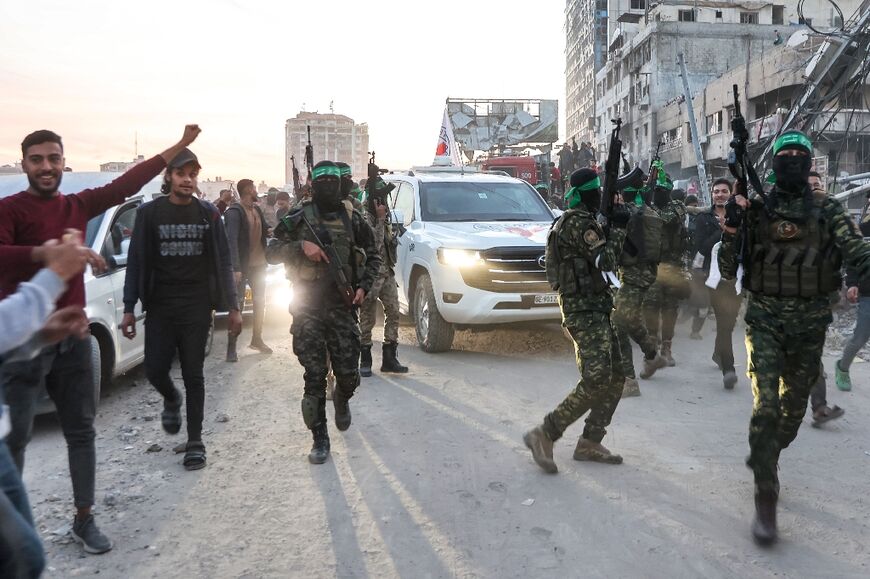 Fighters of the Ezzedine al-Qassam Brigades, Hamas's armed wing, escort ICRC vehicles in Saraya Square in western Gaza City