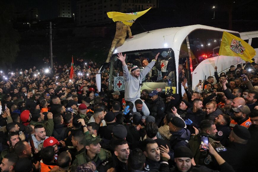 A crowd welcomes Palestinians formerly detained by Israel as they arrive in an ICRC convoy to Ramallah