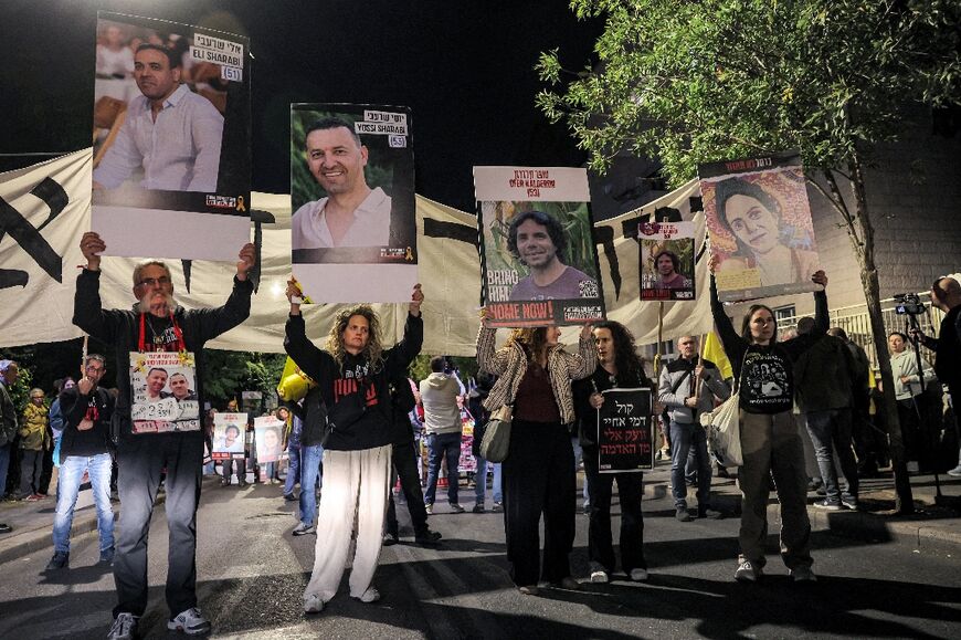 Eli Sharabi, whose portrait is held up at left during a protest by hostage families, is believed alive and on the list for release but his brother Yossi, second from left, died in captivity