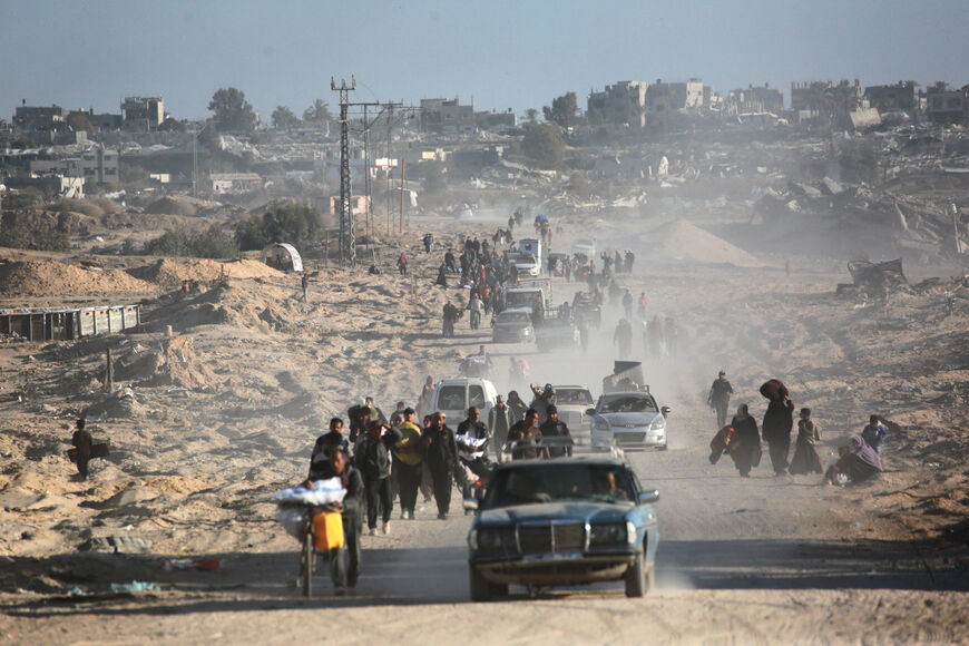 Palestinians transport belongings amidst building rubble in a ruined neighbourhood of Gaza's southern city of Rafah on January 20, 2025, as residents return following a ceasefire deal a day earlier between Israel and the Palestinian Hamas group. (Photo by BASHAR TALEB / AFP) (Photo by BASHAR TALEB/AFP via Getty Images)