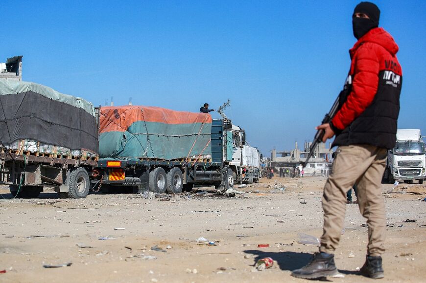 A member of security forces loyal to Hamas stands guard as aid trucks arrive in Al-Shoka, east of Rafah.