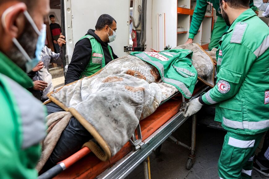 Palestine Red Crescent paramedics at Al-Ahli Arab Hospital in Gaza City move the body of their colleague Mahmud al-Muhadad, after Israeli air strikes