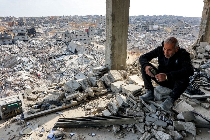 A man sits by rubble in a heavily damaged building in Jabalia in the northern Gaza Strip