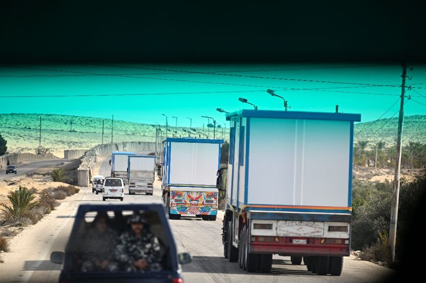 Egyptian soldiers accompany trucks carrying prefabricated houses in Egypt's northern Sinai peninsula, toward the border with the Gaza Strip, after the ceasefire began 