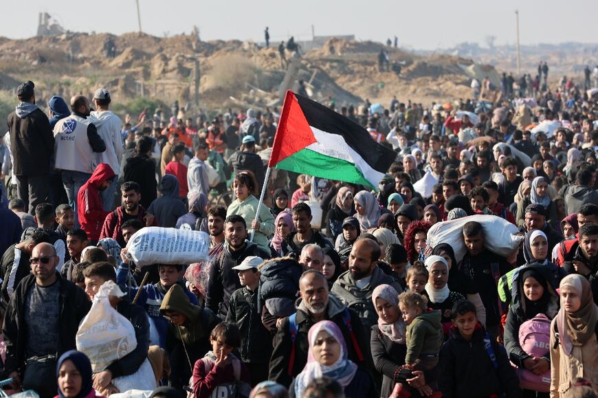 People walk along Gaza's coastal al-Rashid Street to cross the Netzarim corridor from the southern Gaza Strip into the north