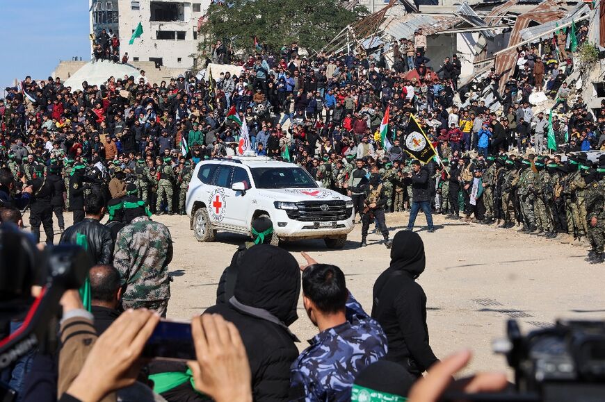 A Red Cross vehicle arrives in a square while Hamas fighters secure the area before releasing four Israeli hostages in Gaza City