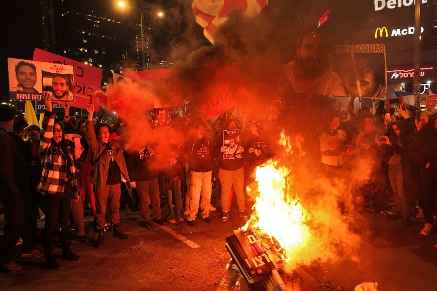 Protesters burn placards during a demonstration calling for the release of hostages held in Gaza on Saturday