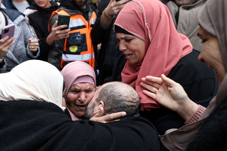 A freed Palestinian prisoner is embraced by family members in the occupied West Bank city of Ramallah