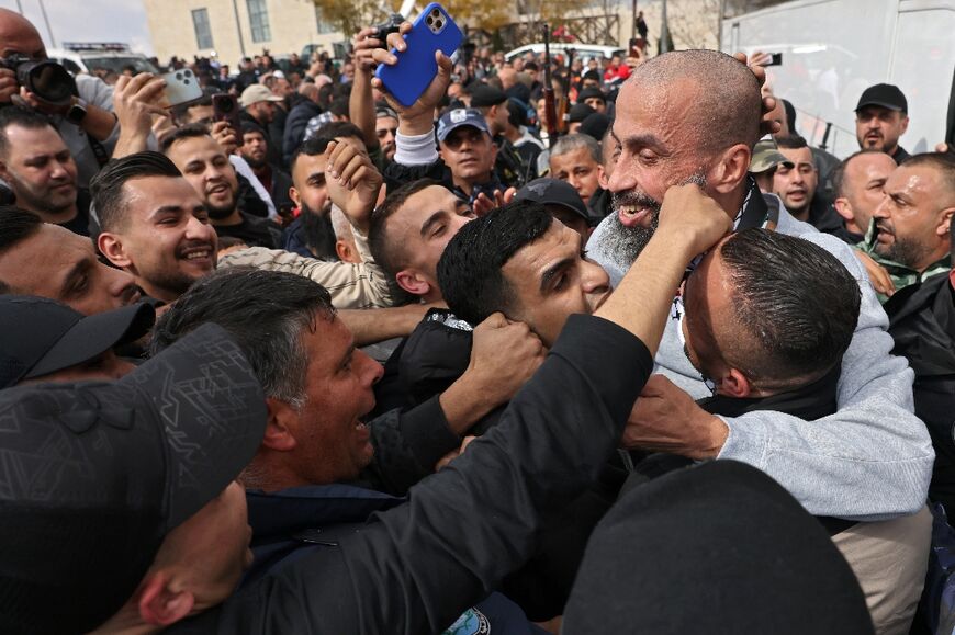 Relatives mob a Palestinian former prisoner after he gets off the Red Cross bus