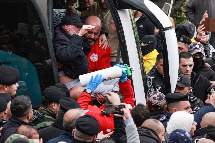 One prisoner was helped off the bus in the arms of a medic while another held his oxygen bottle