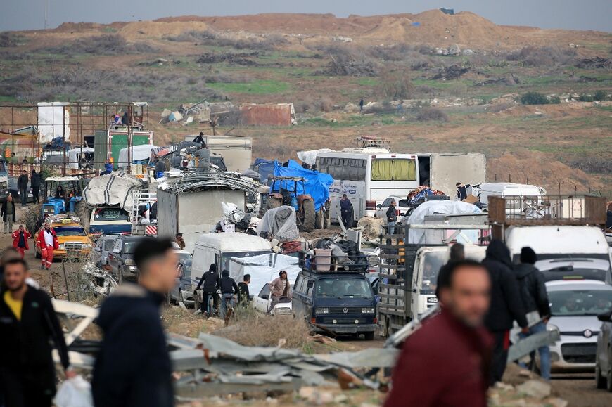 Displaced Palestinians wait to cross a checkpoint manned by Egyptian and US security in the Gaza Strip