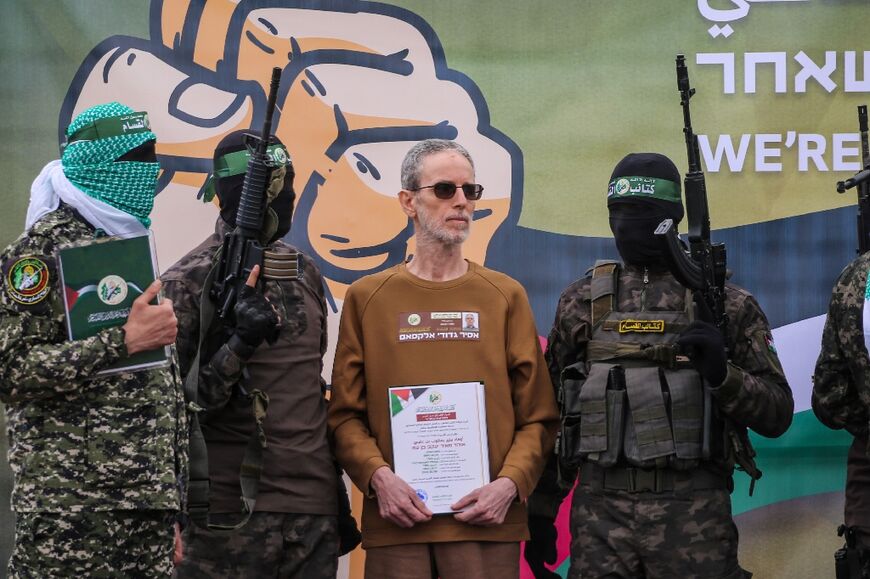 Hamas fighters escort Ohad Ben Ami on a stage before handing him over to a Red Cross team in Deir el-Balah, central Gaza