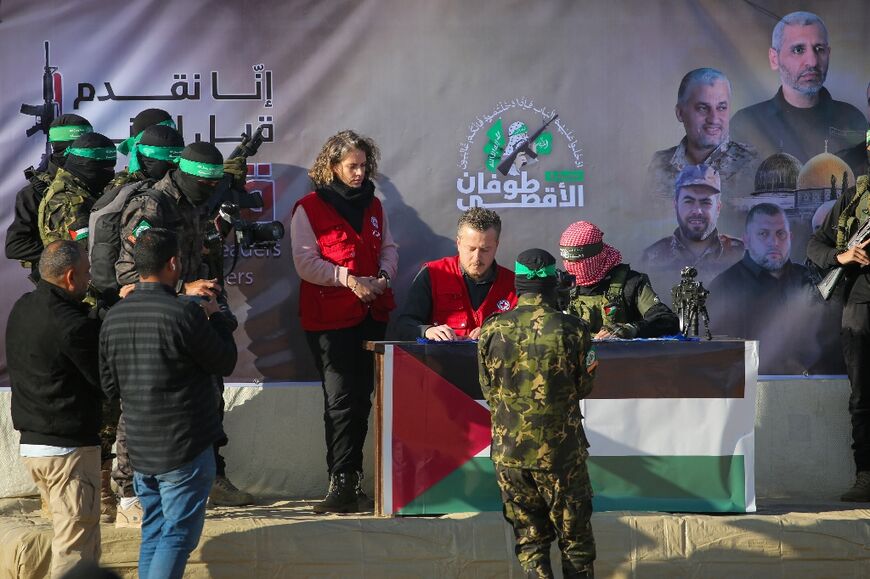 A Red Cross team member signs documents before the Hamas handover of two Israeli hostages in Khan Yunis