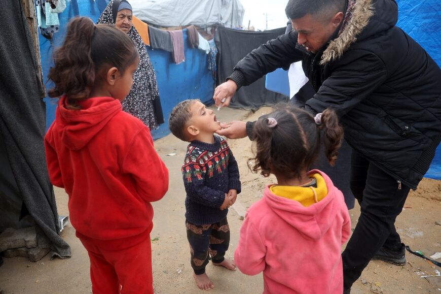 A Palestinian child at a camp for displaced people in Nuseirat, central Gaza, receives a polio vaccine in the third mass polio vaccination campaign for the territory