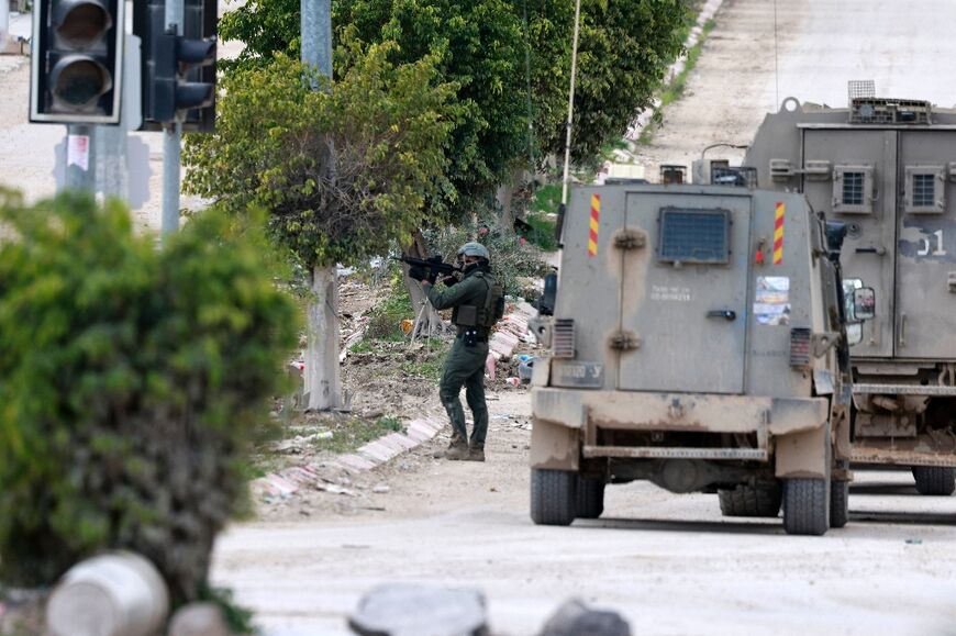 An Israeli soldier takes aim at the entrance to the occupied West Bank refugee camp of Tulkarem