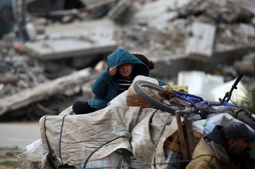 A child sits atop family belongings as they drive through Bureij refugee camp in central Gaza