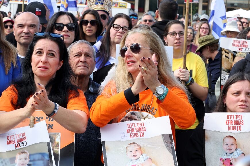 Onlookers with pictures of Kfir Bibas, the youngest Israeli captive in Gaza, cheer while watching the hostage releases