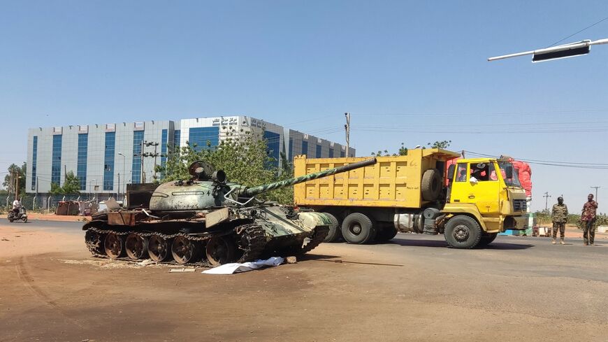 A truck drives past a Sudanese army tank at the entrance of Wad Madani in Sudan's al-Jazira state on Feb. 20, 2025.