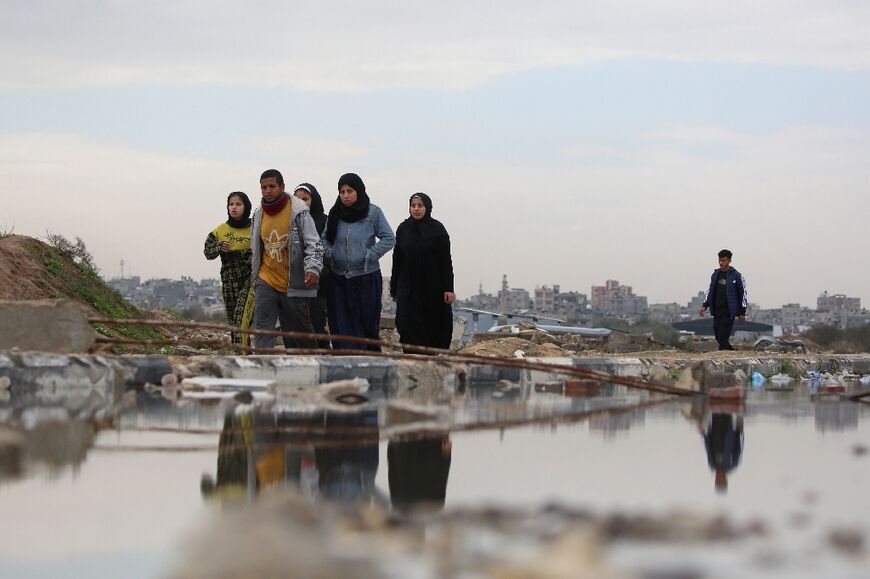 Civilians walk in al-Mughraqa, central Gaza, as displaced people move towards the north of the territory, where the UN has said around 69 per cent of buildings are destroyed or damaged