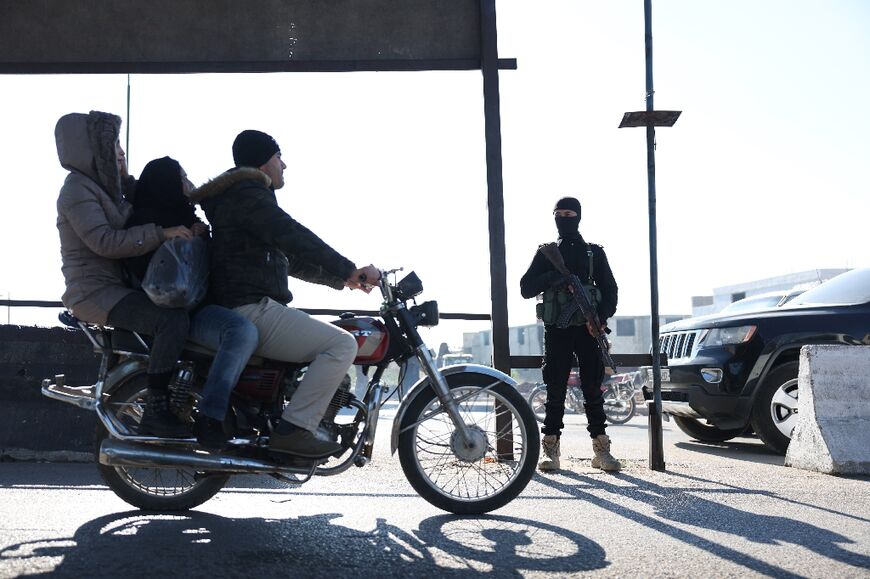 A member of the security forces mans a checkpoint at the entrance to the town of Jableh