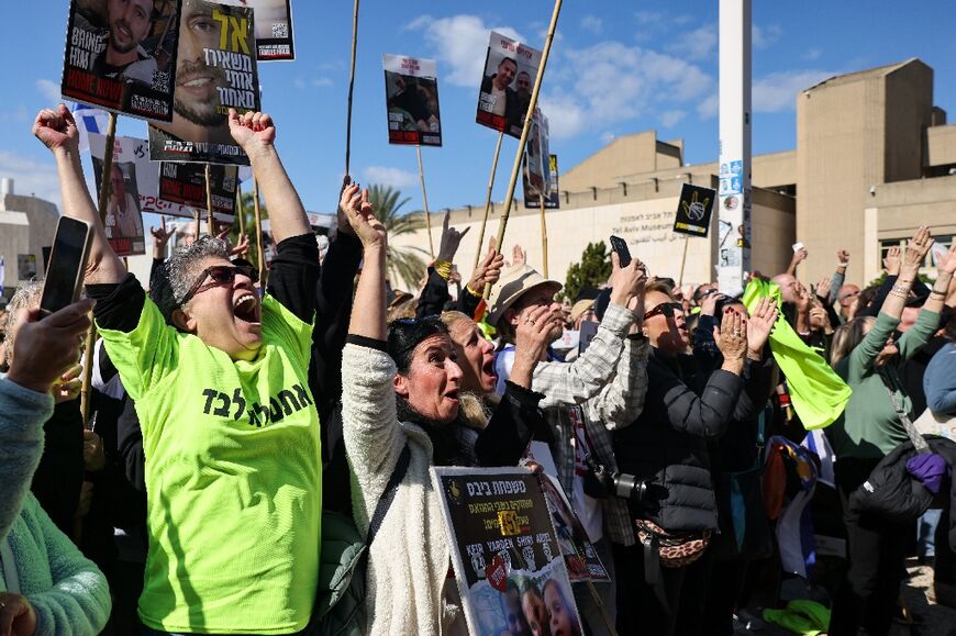 People cheer as they watch three Israeli hostages being released by Hamas in the Gaza Strip, on a large screen in Tel Aviv