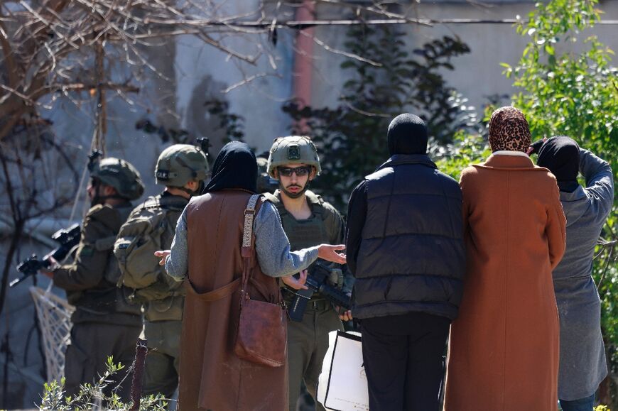 Israeli soldiers prevent displaced Palestinian women from returning to their homes to retrieve belongings at the Jenin refugee camp in the occupied West Bank on February 25, 2025