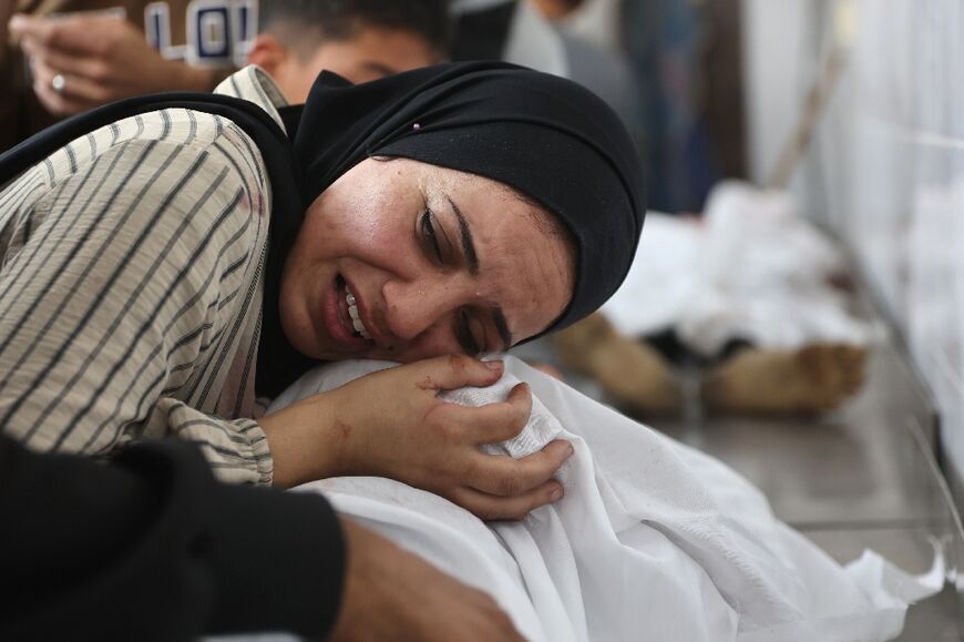 A Palestinian woman mourns over the shrouded body of the victim of a strike in Gaza City