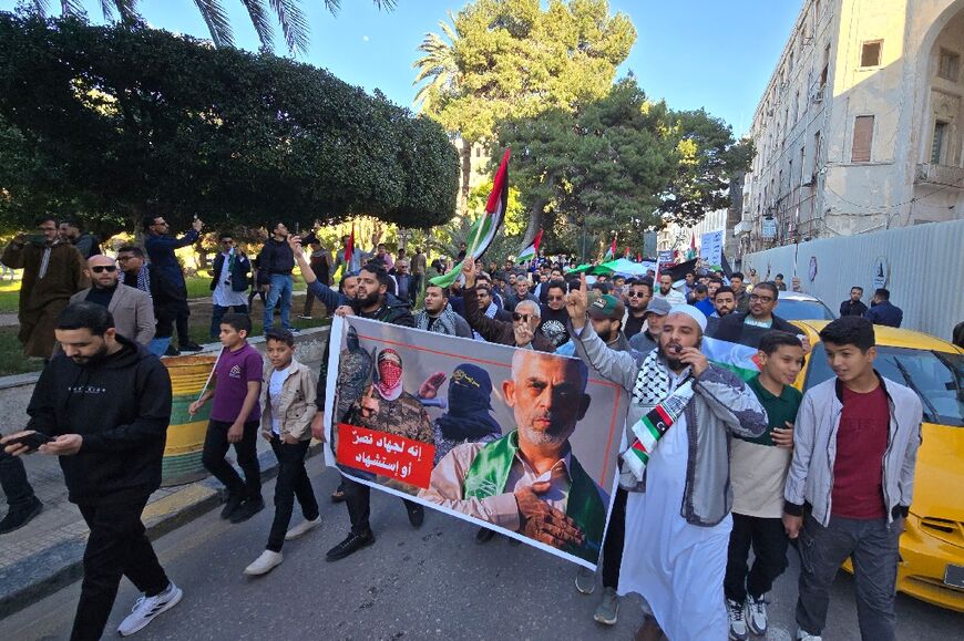 Libyans carry a poster showing slain Hamas leader Yahya Sinwar (R) during a demonstration in solidarity with the Palestinian people, on April 8, 2025 in Tripoli