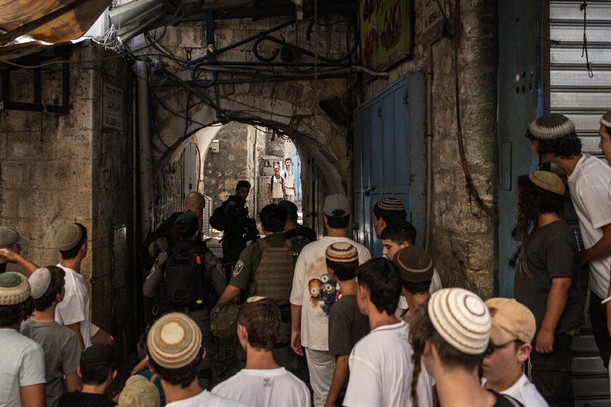Israeli marchers shout at two Palestinian schoolchildren in Jerusalem's Old City during a celebrations for Jerusalem Day on Monday