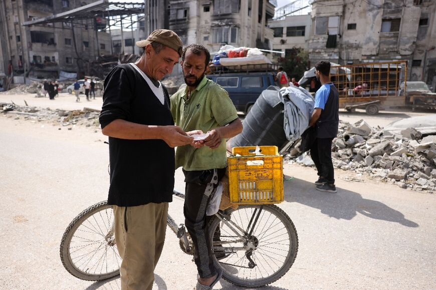 Palestinian men read a leaflet dropped by the Israeli army over Jabalia warning residents to flee south on Thursday
