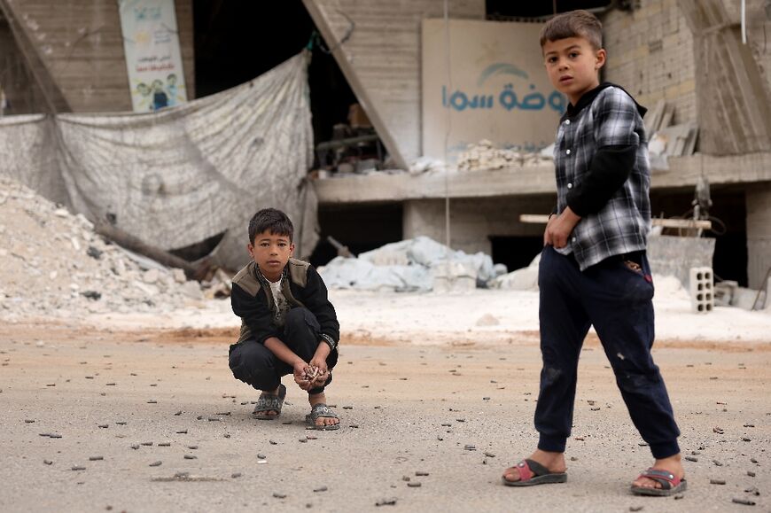 Boys collect bullet casings after the fighting in Sahnaya near Damascus