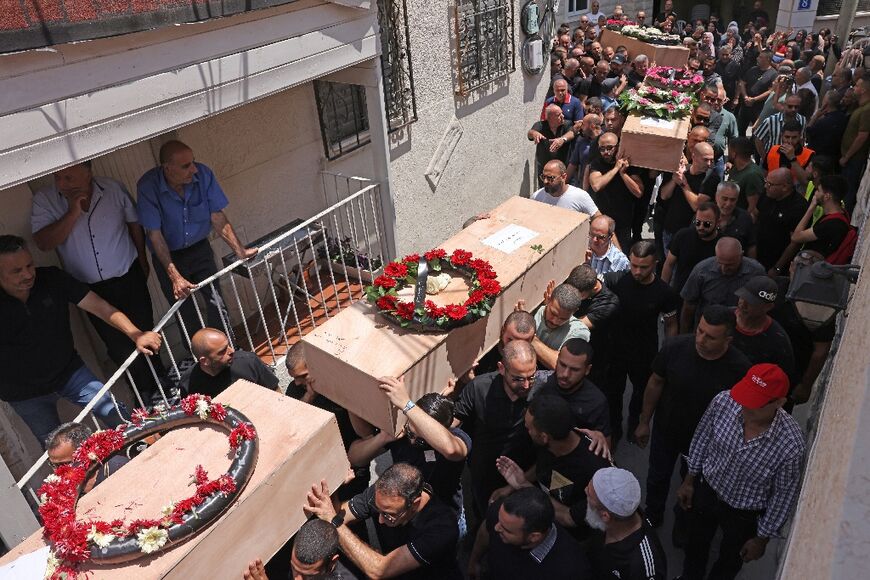 Mourners carrying caskets in Tamra on Tuesday 