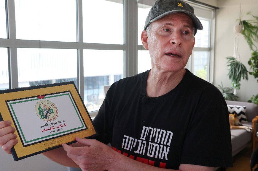 Siegel holds a certificate he received from the armed wing of Hamas on the day he was released from Gaza
