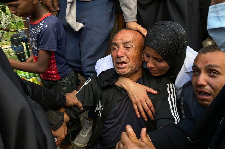 Palestinians mourn relatives killed near a US-backed aid center in the Rafah area, in the southern Gaza Strip