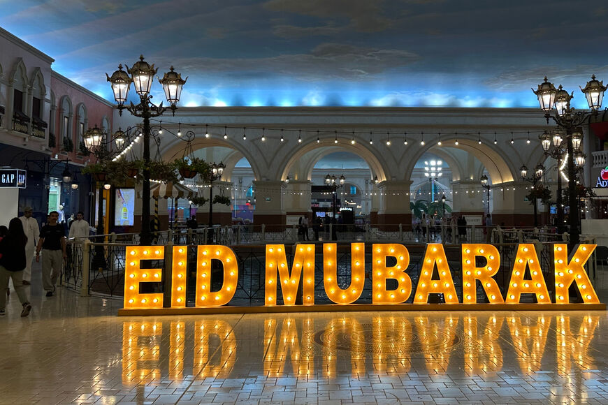 A large sign reads "Eid Mubarak" Happy Eid in Arabic at a mall in Doha, ahead of Eid al-Adha, the Muslim feast of sacrifice on June 4, 2025. (Photo by Karim JAAFAR / AFP) (Photo by KARIM JAAFAR/AFP via Getty Images)